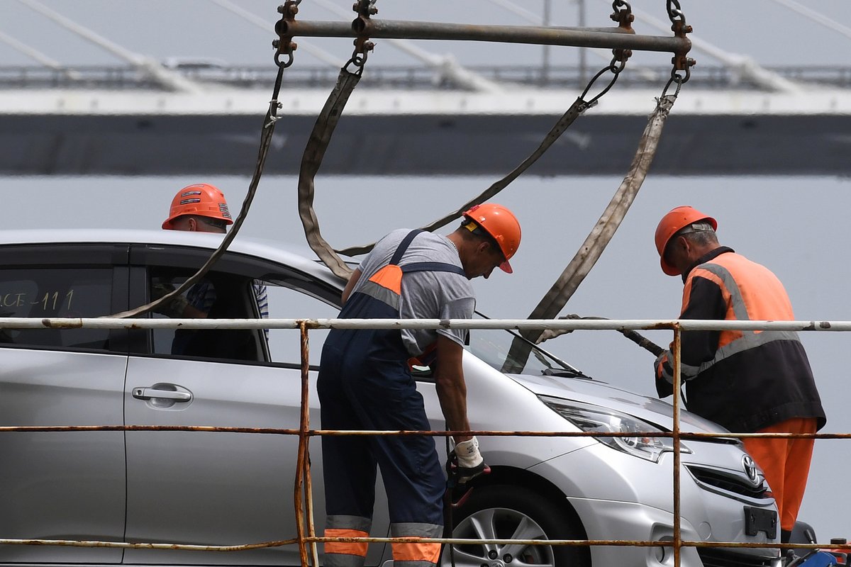 Работники торгового порта во время разгрузки подержанных японских автомобилей во Владивостоке