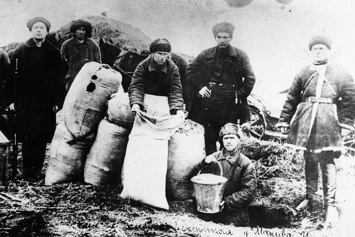 Члены рабочей бригады изымают скрытый кулаками хлеб