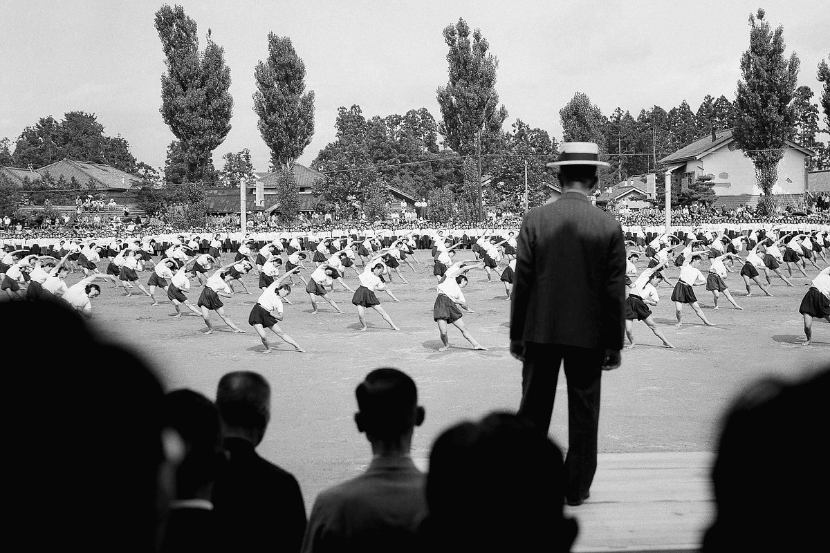 Школьницы из префектуры Иватэ выполняют гимнастические упражнения для императора Хирохито (спиной к камере), Япония, 10 августа 1947 года 