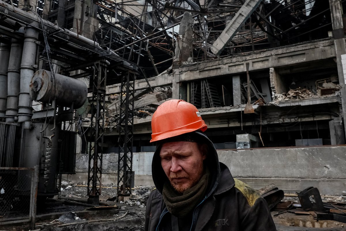 Сотрудник ТЭЦ идет по территории поврежденной электростанции, 13 ноября 2025 года