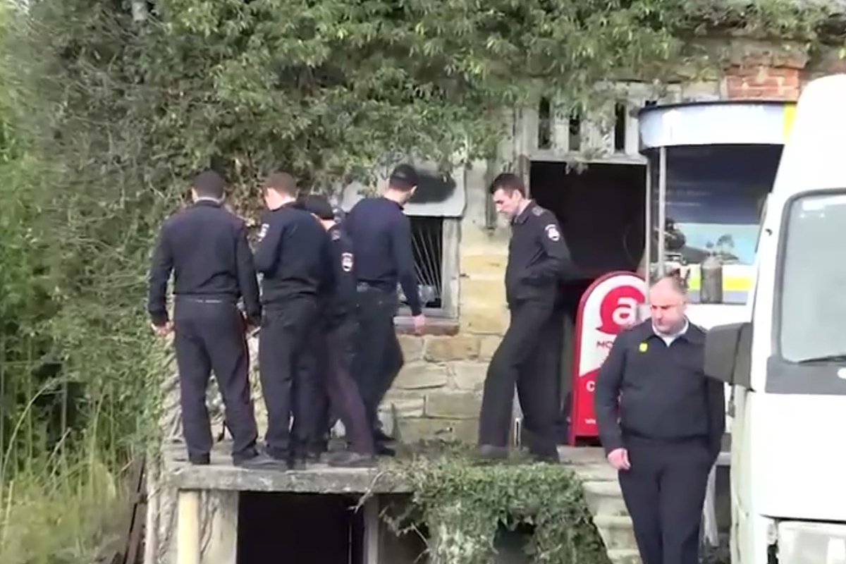 Полицейские осматривают место, откуда киллер вел огонь по траурной процессии на прощании с криминальным авторитетом Адлейбой