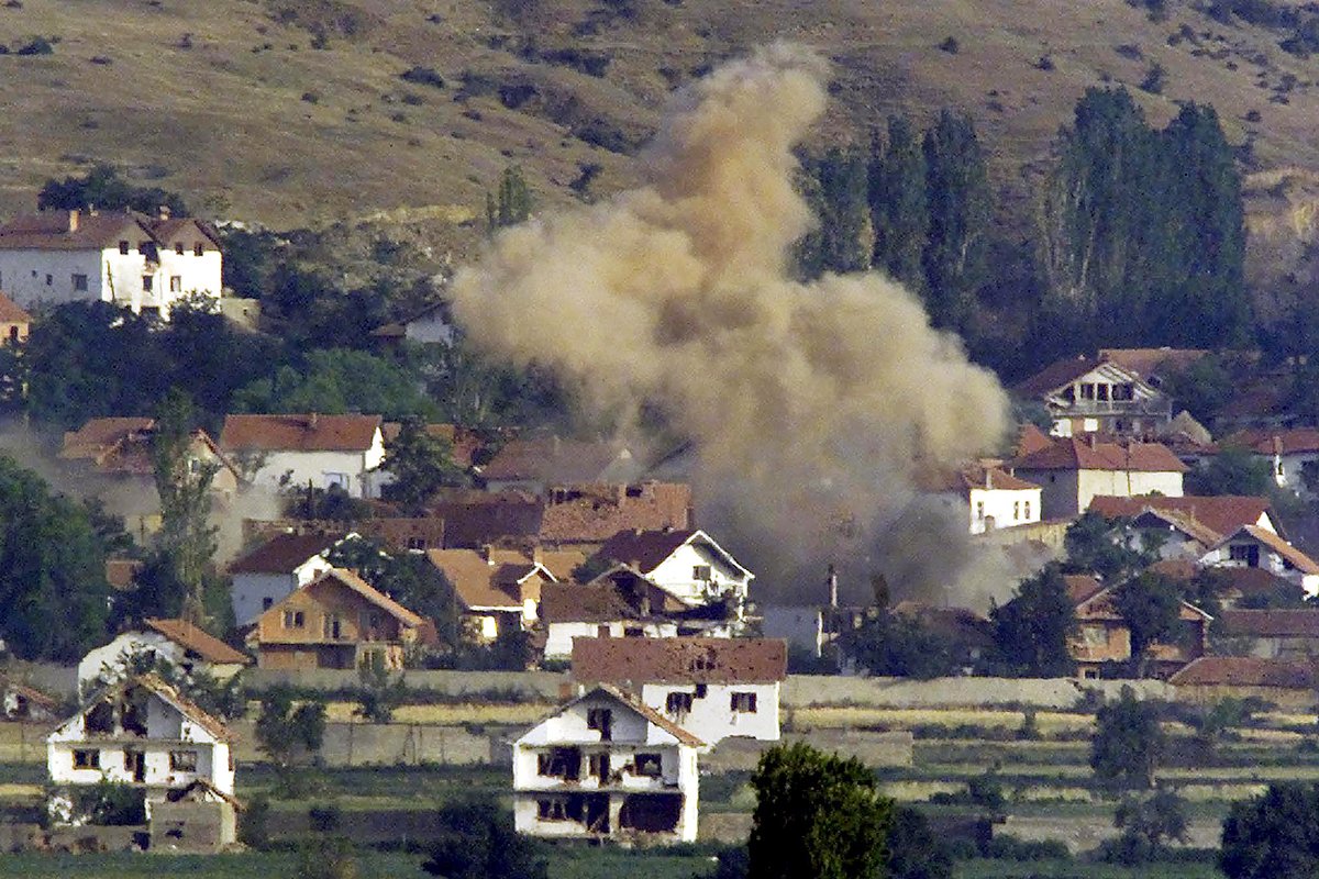 Деревня Слупчане окутана клубами дыма во время утреннего обстрела македонскими войсками 11 июня 2001 года, когда артиллерия, танки и вертолеты обстреливали деревни, удерживаемые албанскими повстанцами на севере Македонии