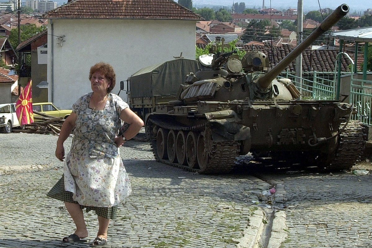 Пожилая женщина проходит мимо танка на окраине Тетово, 28 августа 2001 года