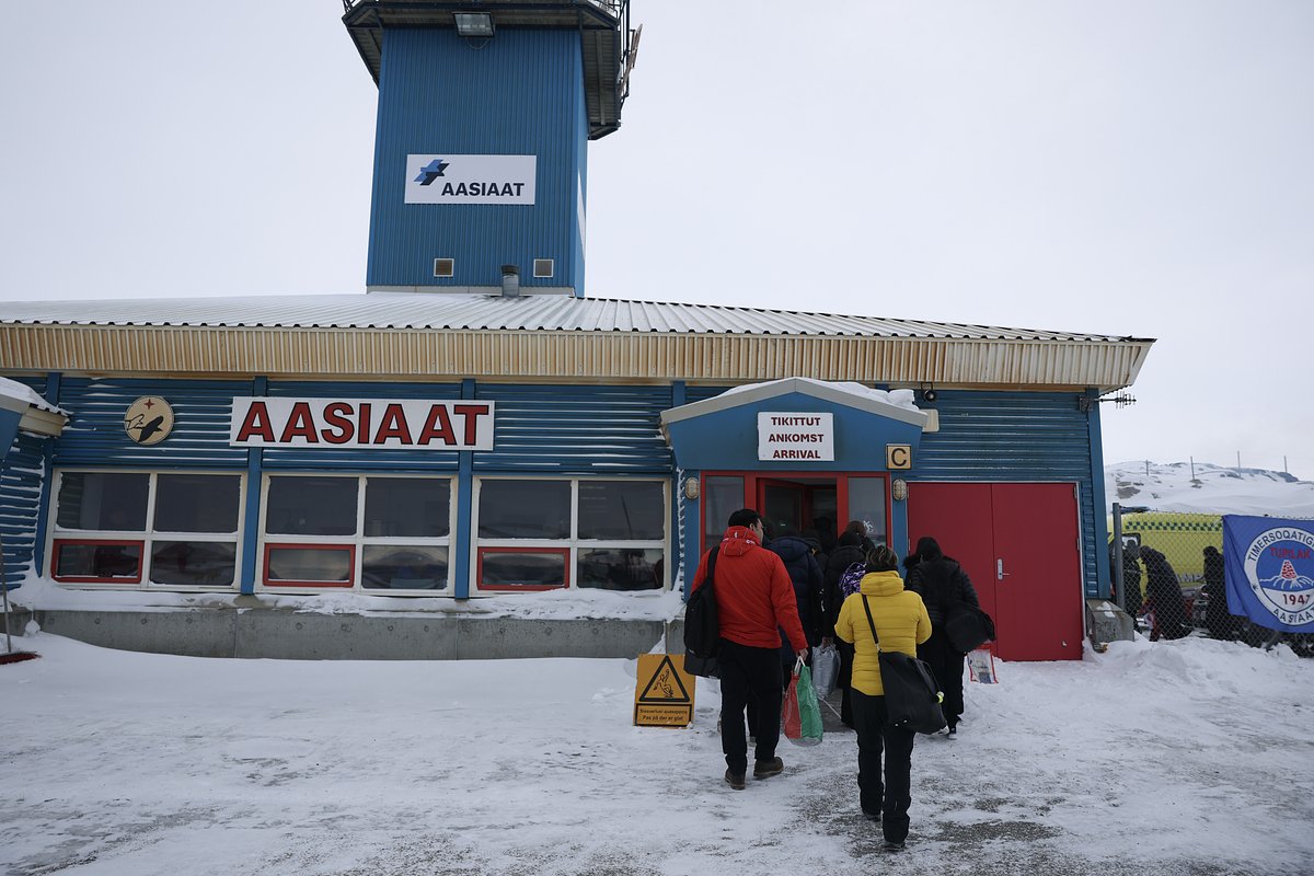 Пассажиры входят в терминал аэропорта Аасиаат; в Гренландии насчитывается всего около 100 миль (161 километр) автомобильных дорог, поэтому большинство путешествий жители совершают на самолетах, вертолетах или лодках, 3 марта 2025 года

