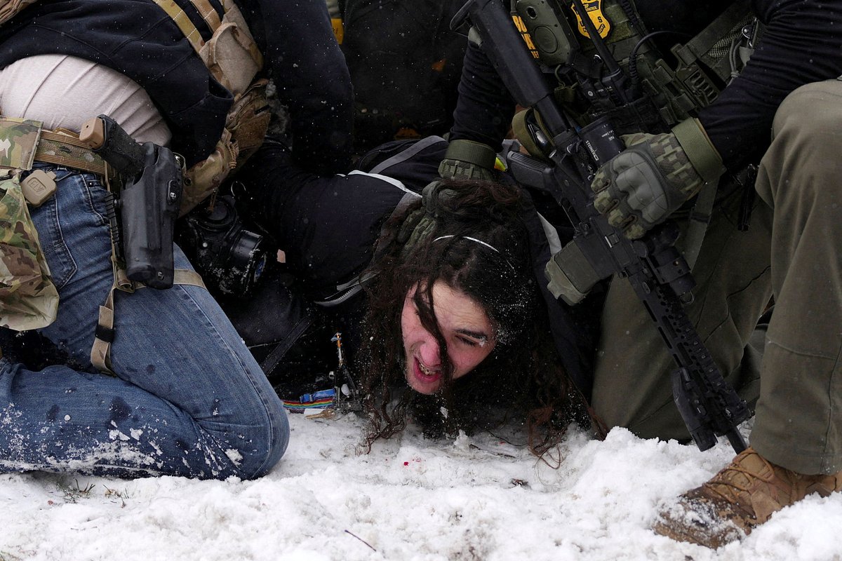 Силовики задерживают демонстранта на митинге против антимигрантских рейдов в Миннеаполисе, Миннесота, США, 25 января 2026 года
