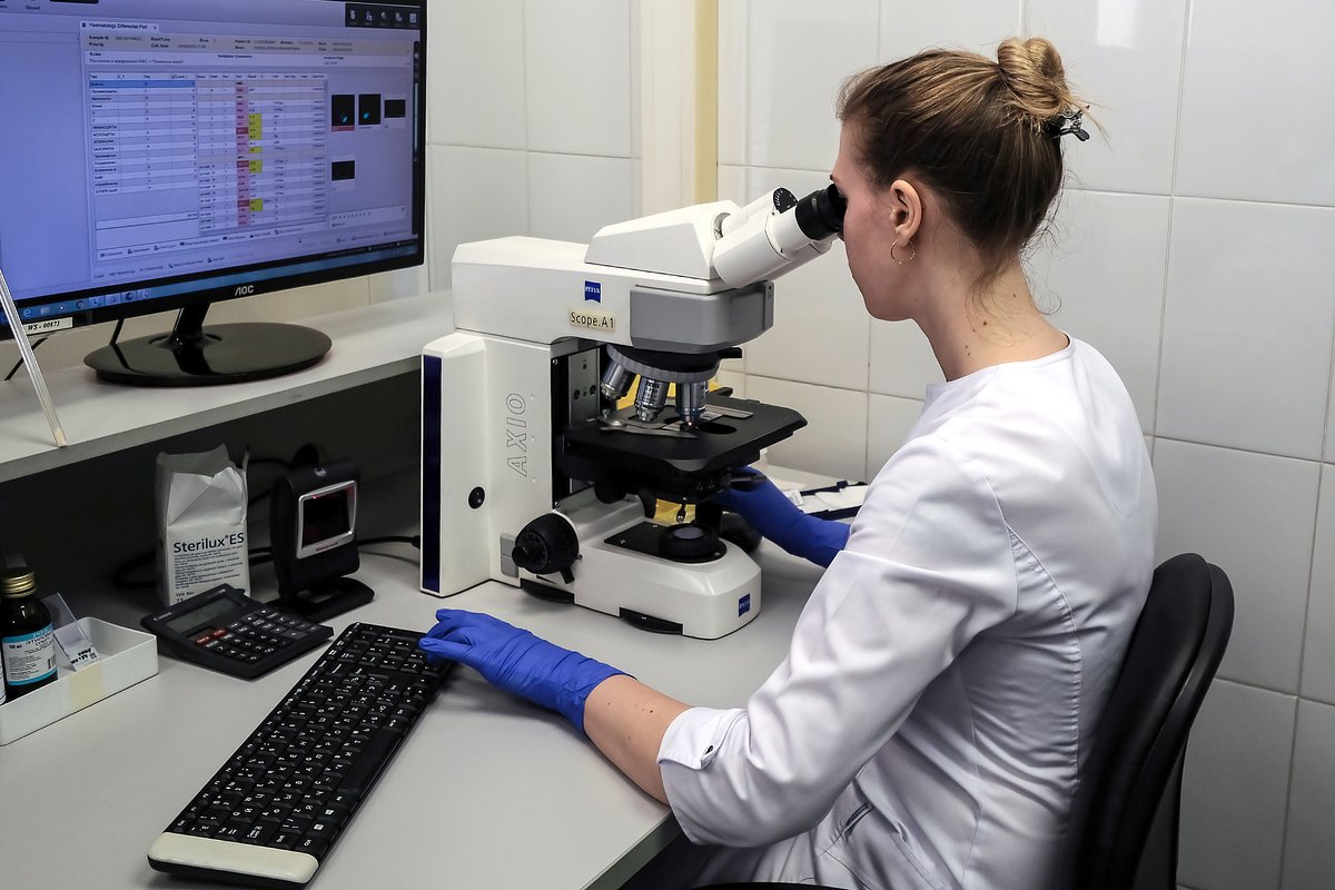 Сотрудница изучает образцы мазков с помощью микроскопа в лаборатории общеклинических исследований в медицинском лабораторном комплексе «Инвитро».
