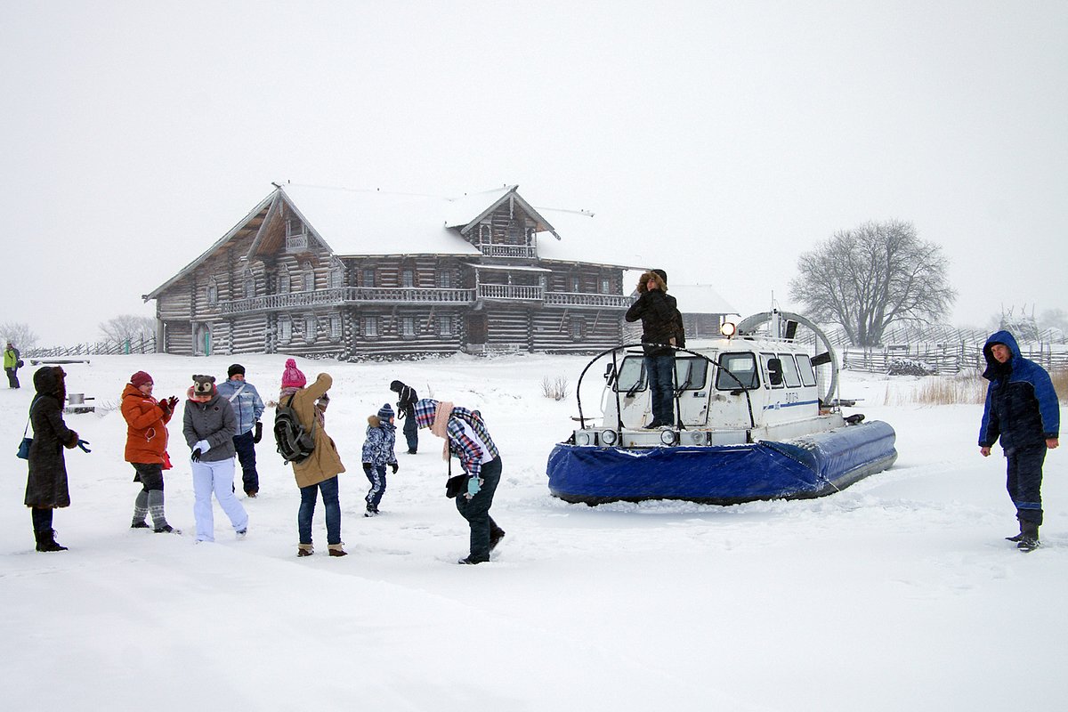 Карелия, Кижи, Россия - Январь 2016 г.: Туристы на фоне судна на воздушной подушке. 