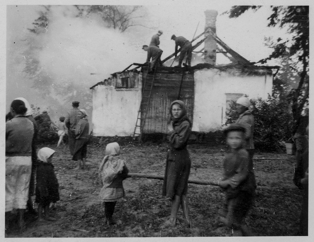 Местные жители расчищают крышу сгоревшего дома. УССР (Украина). 1941 год