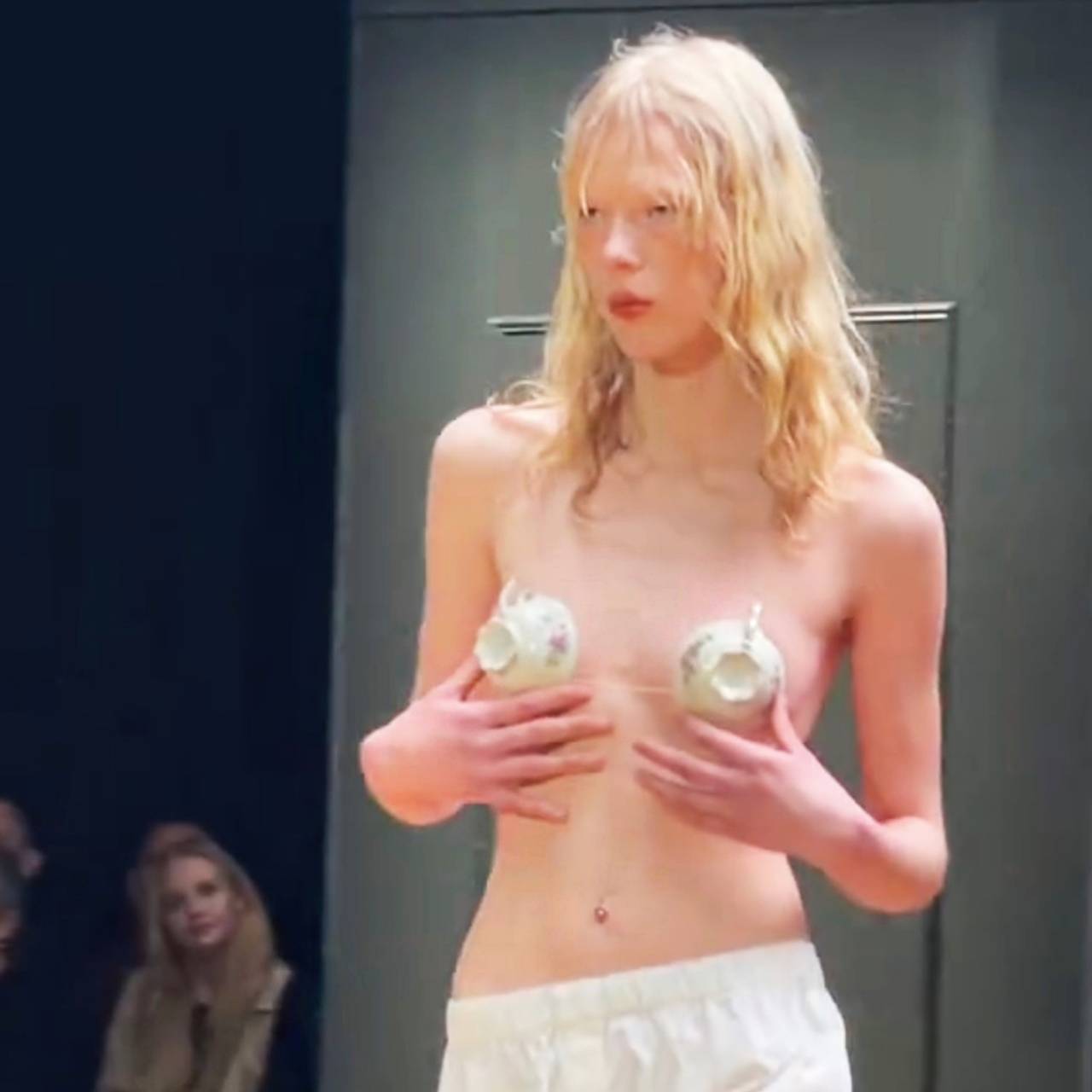 Модель прикрыла голую грудь посудой на показе