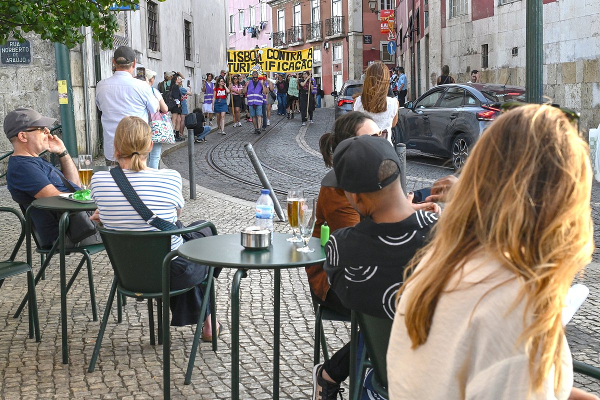 Туристы наблюдают за протестами в Португалии
