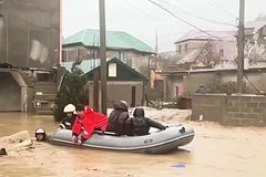 Сотрудники МЧС эвакуируют жителей из домов на подтопленной улице