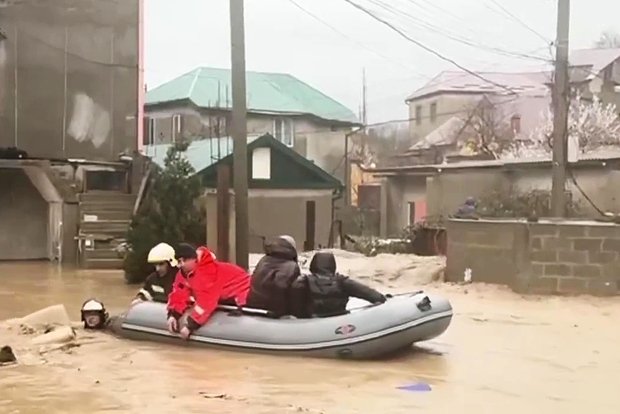 Сотрудники МЧС эвакуируют жителей из домов на подтопленной улице