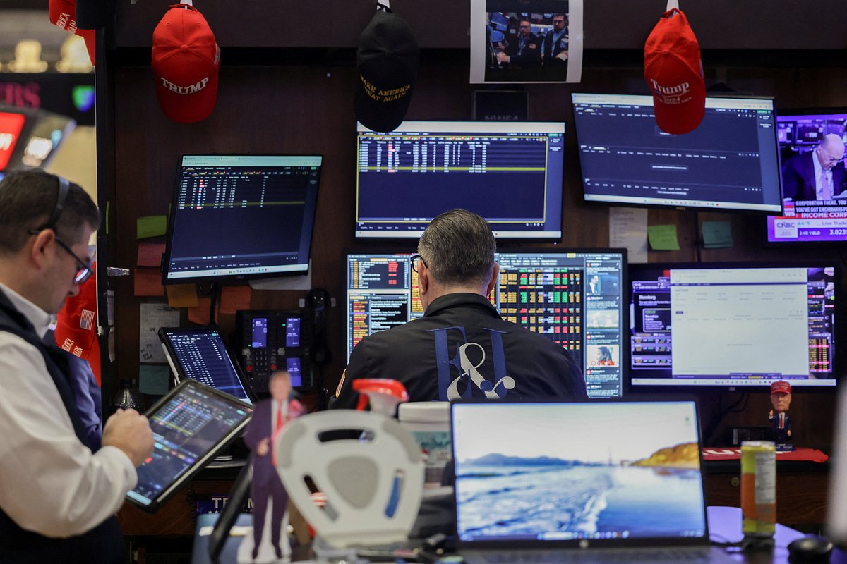 Traders work on the floor at the New York Stock Exchange (NYSE) in New York City
