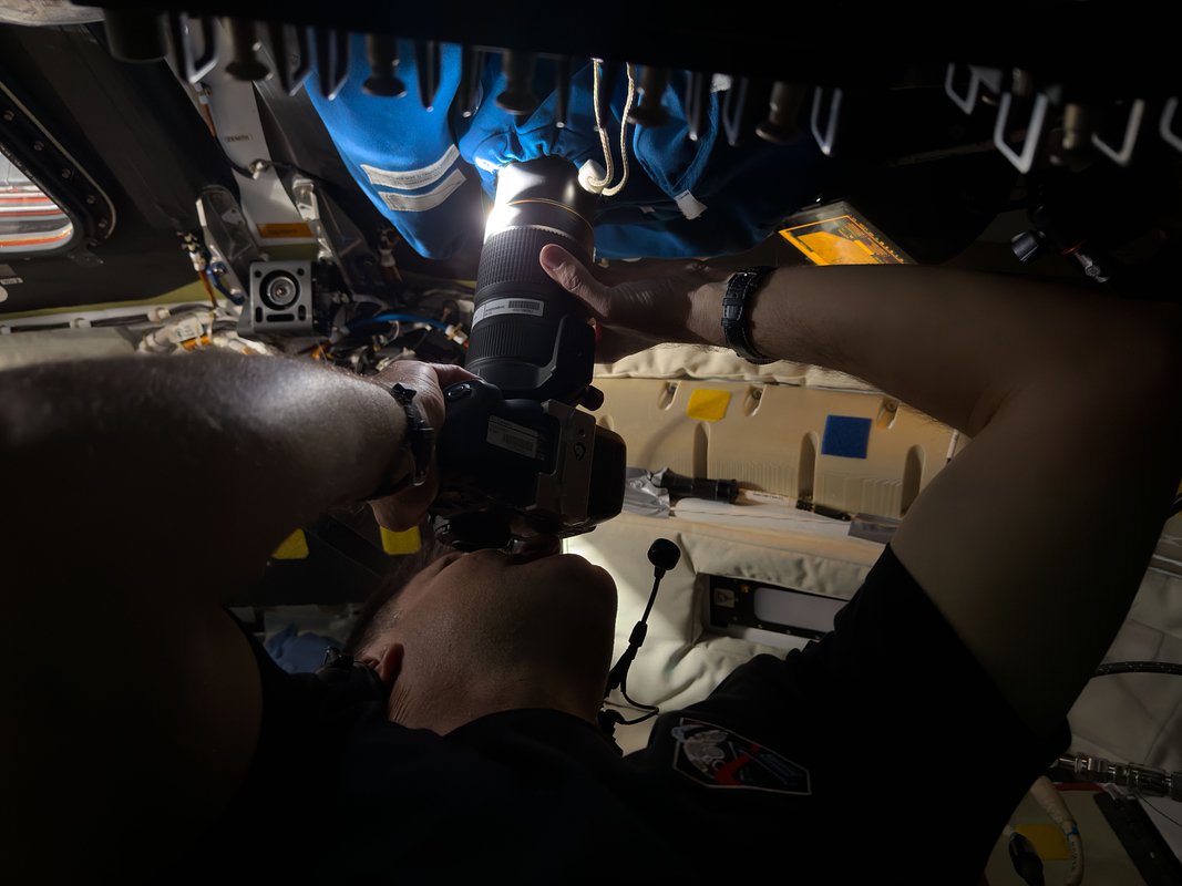 Канадский астронавт Джереми Хансен делает снимок через один из иллюминаторов космического корабля