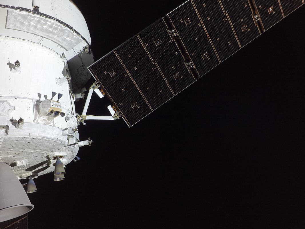 Корабль Orion на снимке с камеры, установленной на одной из его солнечных панелей. На фотографии можно увидеть служебный модуль с тремя из восьми вспомогательных двигателей, а также одну из четырех солнечных панелей