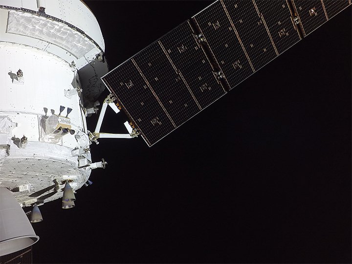 Корабль Orion на снимке с камеры, установленной на одной из его солнечных панелей. На фотографии можно увидеть служебный модуль с тремя из восьми вспомогательных двигателей, а также одну из четырех солнечных панелей