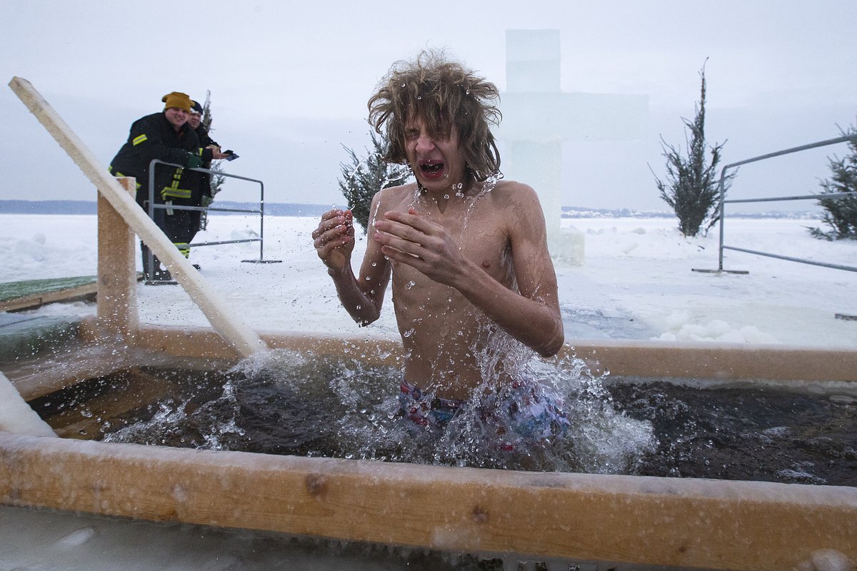A man bathes in the icy waters of Klyazma river during a traditional Epiphany celebration as the temperature dropped to about -20 degrees (-4 degrees Fahrenheit) outside Moscow, Russia, Tuesday, Jan. 19, 2021. Water that is blessed by a cleric on Epiphany is considered holy and pure until next year's celebration, and is believed to have special powers of protection and healing. The Russian Orthodox Church follows the old Julian calendar, according to which Epiphany falls on Jan. 19