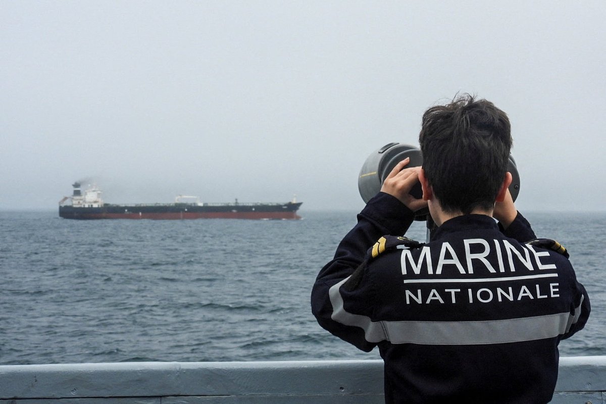 Военнослужащий ВМС Франции наблюдает за нефтяным танкером, связанным с Россией