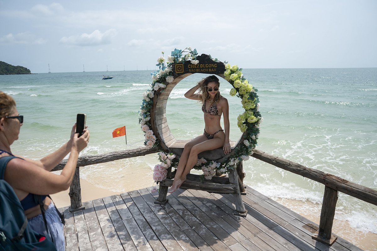 Туристка позирует для фотографии в баре Sao Beach Bar на пляже Бай Там Сао в марте 2026 года на острове Фукуок