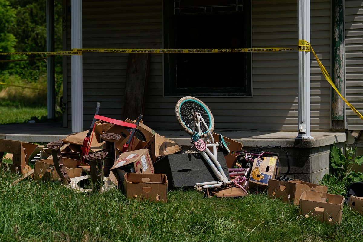 Police tape and debris are seen at a home where authorities say they removed 16 children and arrested four adults in Hamden, Ohio, Wednesday, July 1, 2026